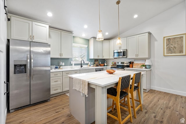 2418 E Quaking Aspen Ln, Eagle Mountain, UT 84005 - kitchen featuring stainless steel appliances, light countertops, light wood-style floors, hanging light fixtures, and recessed lighting