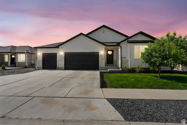 2418 E Quaking Aspen Ln, Eagle Mountain, UT 84005 - view of front of home featuring a garage, driveway, a lawn, board and batten siding, and stone siding