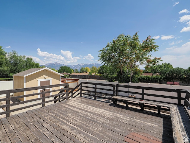 2333 W Ledgewood Dr, Taylorsville, UT 84129 - wooden terrace with a mountain view, a fenced backyard, and a storage unit