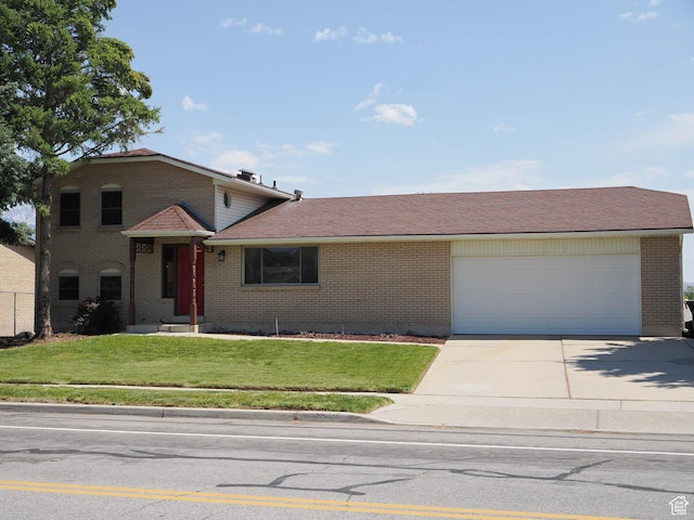2333 W Ledgewood Dr, Taylorsville, UT 84129 - split level home featuring brick siding, concrete driveway, a garage, and a front lawn