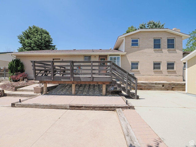 2333 W Ledgewood Dr, Taylorsville, UT 84129 - rear view of property featuring brick siding, a patio, and a wooden deck