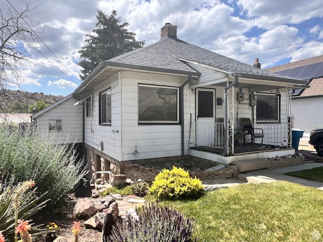 148 Duchesne St, Helper, UT 84526 - view of front of home with covered porch, a chimney, roof with shingles, and a front yard