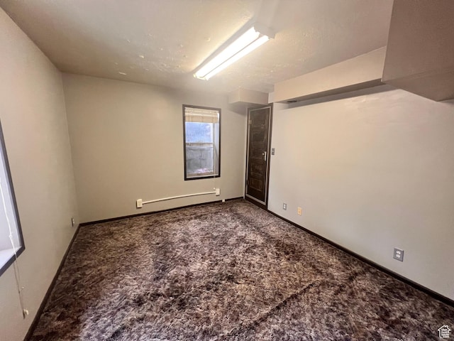 148 Duchesne St, Helper, UT 84526 - carpeted empty room featuring a baseboard heating unit and baseboards