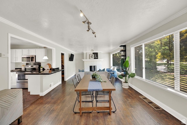 2270 E 1700 S, Salt Lake City, UT 84108 - dining room with a brick fireplace, dark wood-style floors, a textured ceiling, ornamental molding, and track lighting