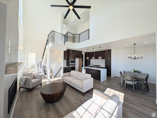 11369 S Watercourse Rd W Unit 202, South Jordan, UT 84009 - living area featuring stairs, wood finished floors, a towering ceiling, a chandelier, and ceiling fan