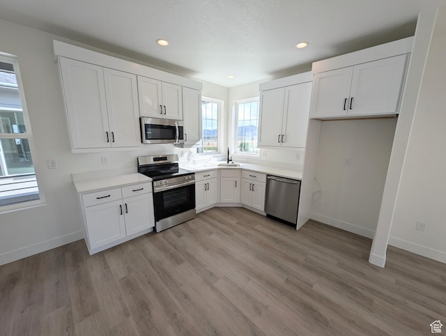 11369 S Watercourse Rd W Unit 202, South Jordan, UT 84009 - kitchen with appliances with stainless steel finishes, light wood-type flooring, white cabinets, light countertops, and recessed lighting