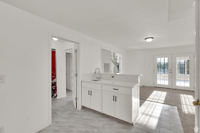 2313 N 850 E, Lehi, UT 84043 - kitchen with white cabinetry, french doors, light countertops, light marble finish floors, and a peninsula