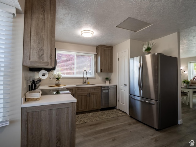 8823 S 3715 W, West Jordan, UT 84088 - kitchen with stainless steel appliances, dark wood-style flooring, a textured ceiling, light countertops, and brown cabinetry