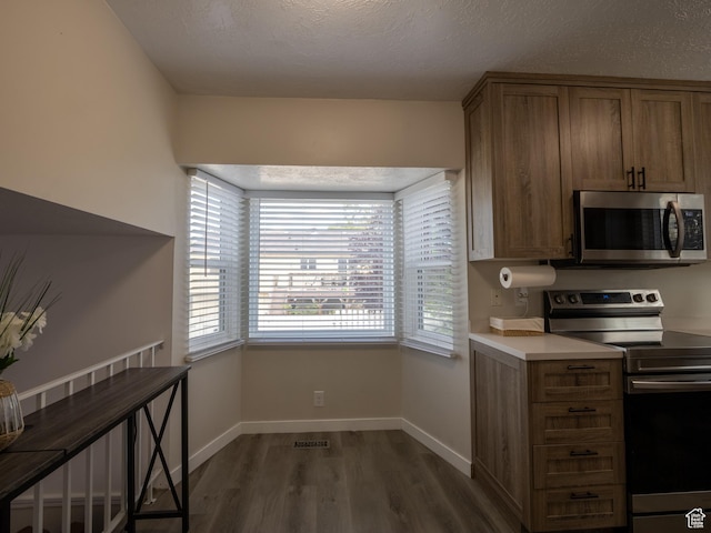 8823 S 3715 W, West Jordan, UT 84088 - kitchen with appliances with stainless steel finishes, dark wood-style flooring, brown cabinetry, light countertops, and a textured ceiling