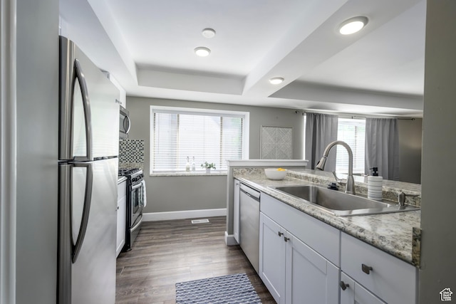 2220 E Murray Holladay Rd S Unit 75, Salt Lake City, UT 84117 - kitchen with a tray ceiling, appliances with stainless steel finishes, dark wood finished floors, white cabinets, and light stone countertops