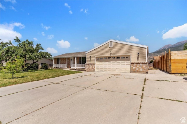 321 E 1040 N, Orem, UT 84057 - ranch-style home featuring brick siding, a porch, an attached garage, a mountain view, and concrete driveway