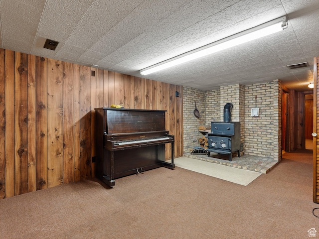 320 S 2nd St W, Soda Springs, ID 83276 - sitting room with a wood stove, carpet flooring, and wooden walls
