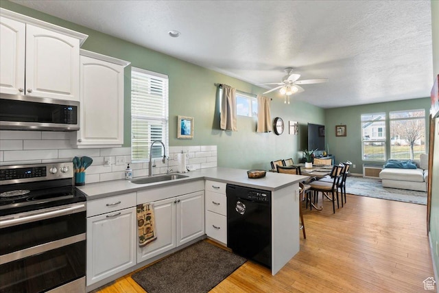 5023 W Currant Dr S, South Jordan, UT 84009 - kitchen featuring stainless steel appliances, a peninsula, light wood-type flooring, a ceiling fan, and a textured ceiling