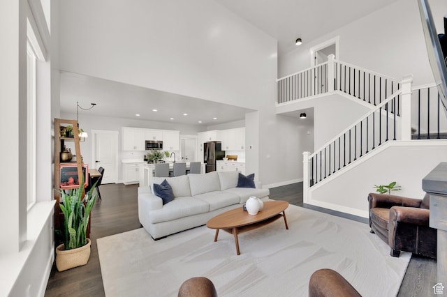 6729 W Dry Peak Dr, Herriman, UT 84096 - living area with a high ceiling, dark wood-type flooring, stairs, and recessed lighting