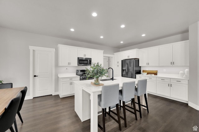 6729 W Dry Peak Dr, Herriman, UT 84096 - kitchen with appliances with stainless steel finishes, light countertops, dark wood-type flooring, recessed lighting, and white cabinetry