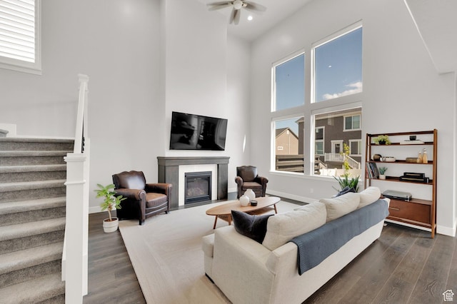 6729 W Dry Peak Dr, Herriman, UT 84096 - living room with a towering ceiling, stairs, ceiling fan, dark wood-style floors, and a fireplace with flush hearth
