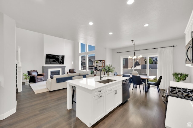 6729 W Dry Peak Dr, Herriman, UT 84096 - kitchen featuring stainless steel appliances, recessed lighting, a glass covered fireplace, white cabinets, and light countertops