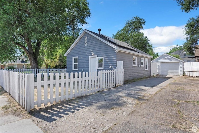 2692 S Monroe Blvd E, Ogden, UT 84401 - view of home's exterior featuring driveway, a detached garage, roof mounted solar panels, and an outdoor structure