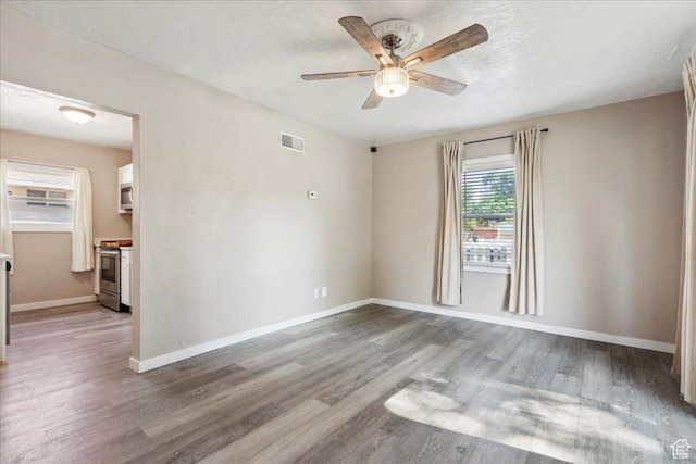2692 S Monroe Blvd E, Ogden, UT 84401 - empty room featuring a ceiling fan, wood finished floors, and a textured ceiling