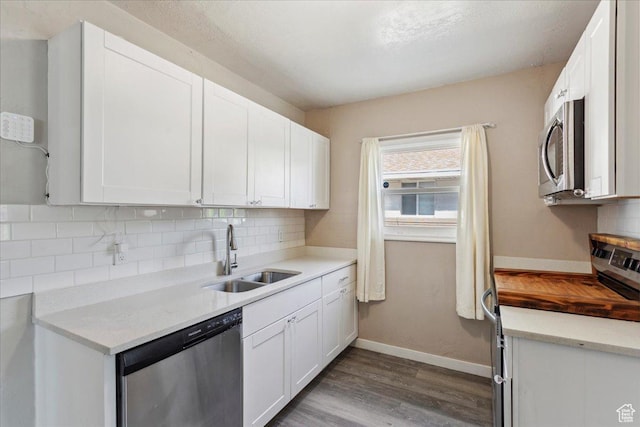 2692 S Monroe Blvd E, Ogden, UT 84401 - kitchen featuring appliances with stainless steel finishes, dark wood-style floors, backsplash, and white cabinets