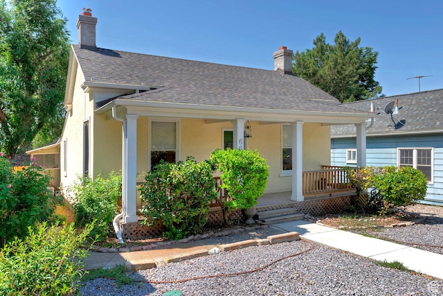 662 E 4th Ave, Salt Lake City, UT 84103 - view of front of house featuring stucco siding, covered porch, a chimney, and roof with shingles