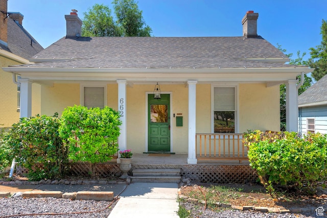 662 E 4th Ave, Salt Lake City, UT 84103 - view of front of home featuring covered porch, stucco siding, roof with shingles, and a chimney