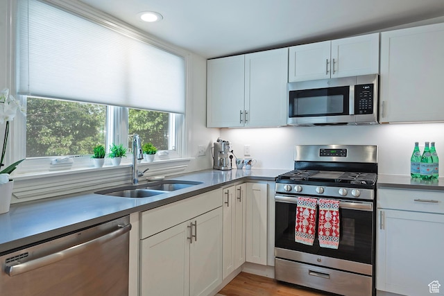 662 E 4th Ave, Salt Lake City, UT 84103 - kitchen featuring appliances with stainless steel finishes, white cabinetry, recessed lighting, and light wood-style floors