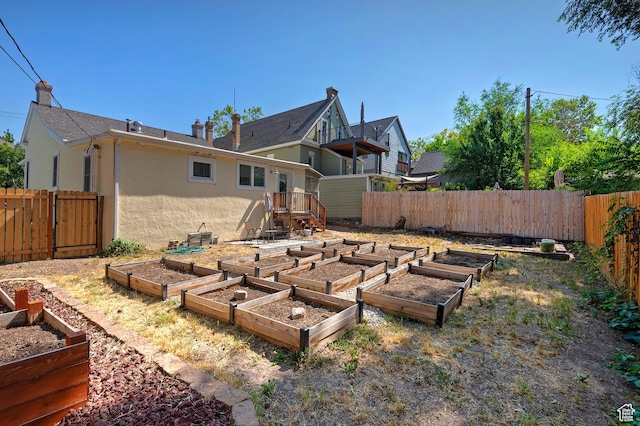 662 E 4th Ave, Salt Lake City, UT 84103 - back of house with stucco siding, a garden, and a fenced backyard
