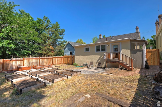 662 E 4th Ave, Salt Lake City, UT 84103 - back of property featuring a vegetable garden, stucco siding, and a chimney