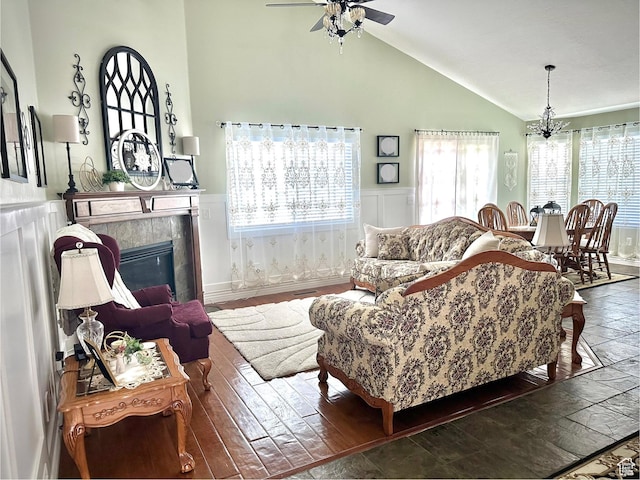 2242 N 2500 W, Lehi, UT 84043 - living room featuring a tile fireplace, a ceiling fan, wainscoting, high vaulted ceiling, and a chandelier