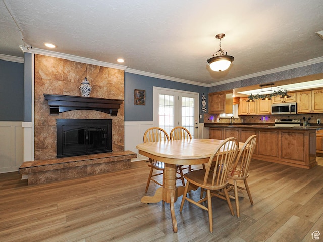 4060 W 2550 S, Taylor, UT 84401 - dining space featuring light wood-style flooring, ornamental molding, wainscoting, french doors, and a textured ceiling