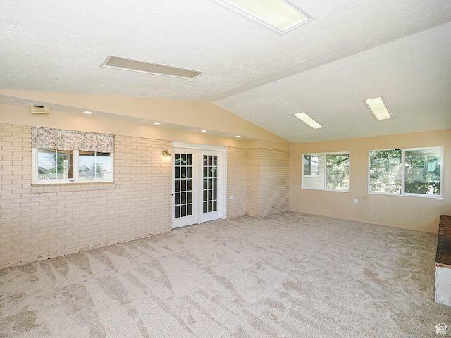 4060 W 2550 S, Taylor, UT 84401 - spare room with brick wall, carpet, lofted ceiling, a textured ceiling, and french doors