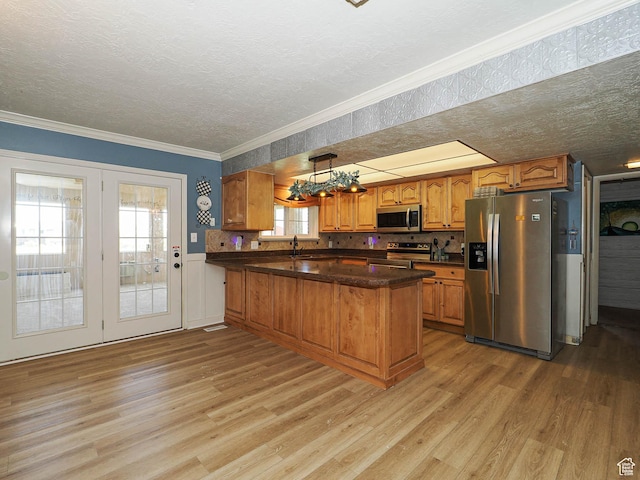 4060 W 2550 S, Taylor, UT 84401 - kitchen featuring stainless steel appliances, light wood-style flooring, brown cabinetry, a peninsula, and a textured ceiling