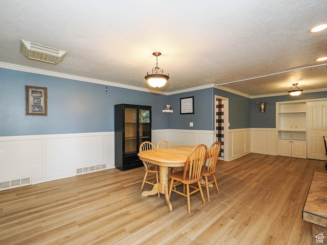 4060 W 2550 S, Taylor, UT 84401 - dining room featuring a textured ceiling, wood finished floors, wainscoting, ornamental molding, and a decorative wall