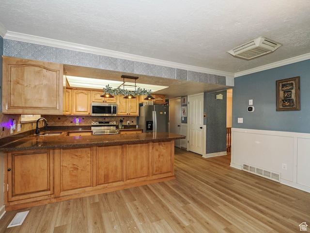 4060 W 2550 S, Taylor, UT 84401 - kitchen featuring appliances with stainless steel finishes, crown molding, a peninsula, light wood-style flooring, and a textured ceiling