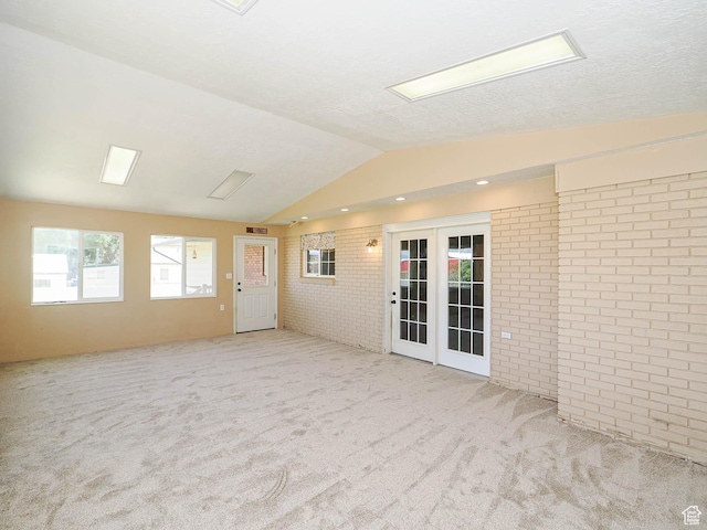 4060 W 2550 S, Taylor, UT 84401 - unfurnished room featuring brick wall, lofted ceiling, carpet, and french doors