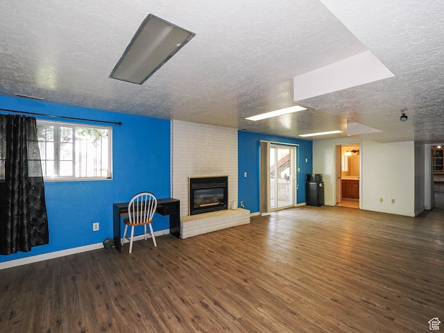 4060 W 2550 S, Taylor, UT 84401 - unfurnished living room featuring a textured ceiling, wood finished floors, a brick fireplace, and plenty of natural light