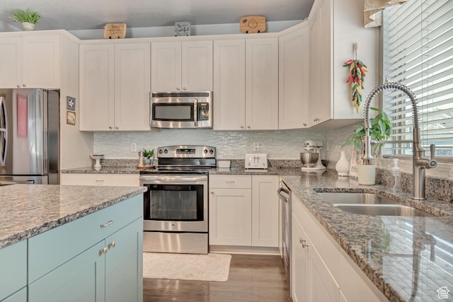 739 S 160 W, American Fork, UT 84003 - kitchen with appliances with stainless steel finishes, wood finished floors, white cabinets, backsplash, and light stone counters