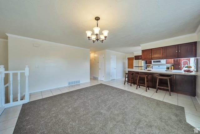 5072 S 1150 E, Ogden, UT 84403 - kitchen featuring freestanding refrigerator, white microwave, light tile patterned floors, a chandelier, and a kitchen breakfast bar