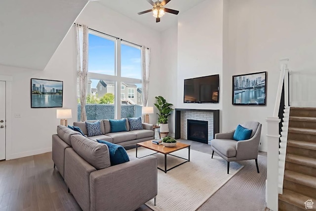 194 N Valcrest Dr, Saratoga Springs, UT 84045 - living area featuring a towering ceiling, a ceiling fan, wood finished floors, stairway, and a fireplace
