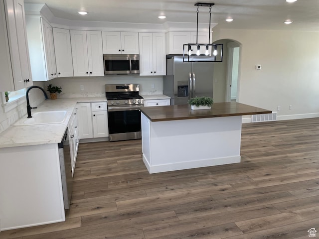 4940 N 5000 W, Roosevelt, UT 84066 - kitchen featuring appliances with stainless steel finishes, a center island, arched walkways, dark wood finished floors, and recessed lighting