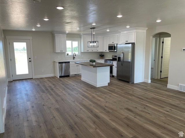 4940 N 5000 W, Roosevelt, UT 84066 - kitchen with stainless steel appliances, arched walkways, white cabinetry, a kitchen island, and dark wood finished floors