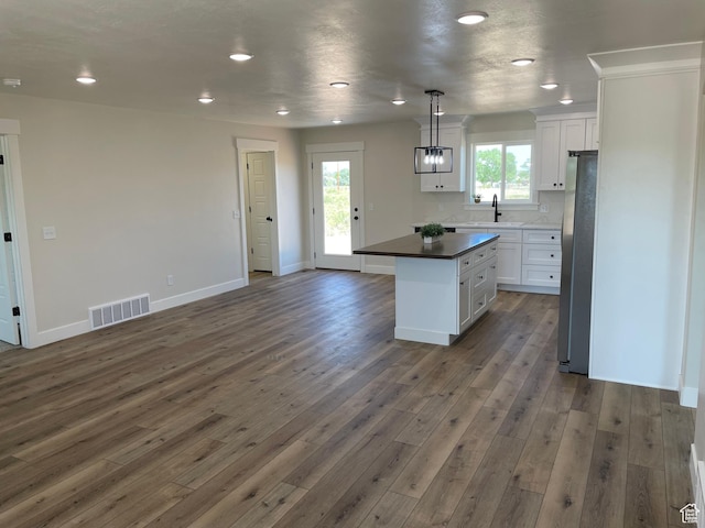 4940 N 5000 W, Roosevelt, UT 84066 - kitchen featuring white cabinets, dark wood-style floors, freestanding refrigerator, and recessed lighting