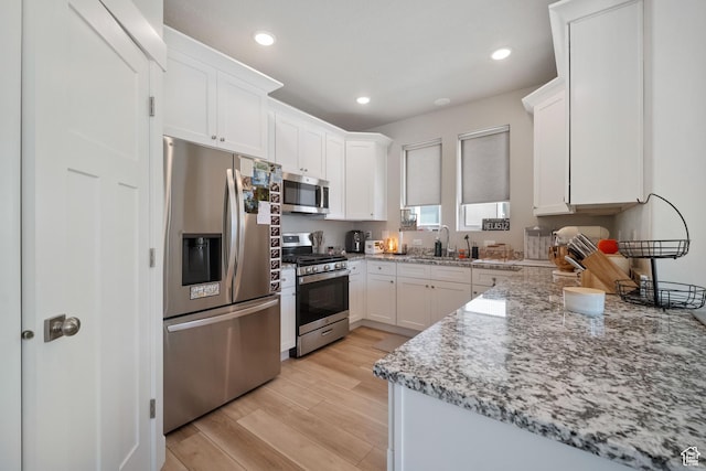 1044 S 2800 E, Spanish Fork, UT 84660 - kitchen with stainless steel appliances, light wood-type flooring, white cabinetry, light stone countertops, and recessed lighting