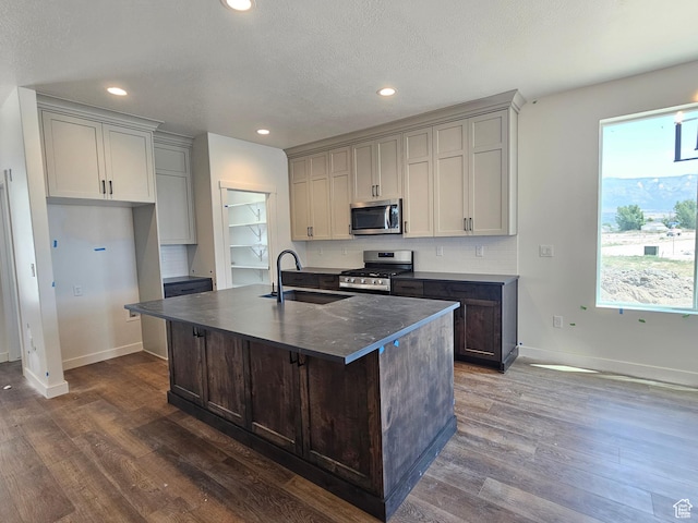 2804 W 2710 N Unit 87, Plain City, UT 84404 - kitchen featuring stainless steel appliances, dark countertops, dark wood-style floors, recessed lighting, and a center island with sink