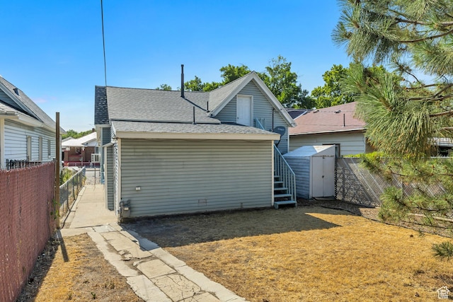 2056 Liberty Ave, Ogden, UT 84401 - rear view of house with roof with shingles, a fenced backyard, and a storage shed