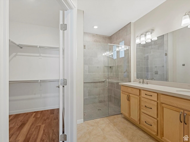 6067 W Whisle Stop Rd S, South Jordan, UT 84009 - full bathroom featuring a shower stall, double vanity, a spacious closet, wood finished floors, and recessed lighting