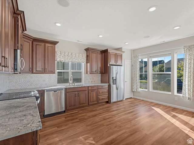 6067 W Whisle Stop Rd S, South Jordan, UT 84009 - kitchen featuring appliances with stainless steel finishes, light wood-type flooring, tasteful backsplash, recessed lighting, and light stone countertops
