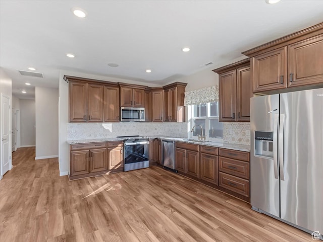 6067 W Whisle Stop Rd S, South Jordan, UT 84009 - kitchen featuring stainless steel appliances, light wood finished floors, decorative backsplash, light stone counters, and recessed lighting