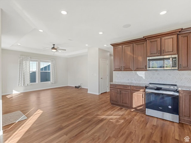 6067 W Whisle Stop Rd S, South Jordan, UT 84009 - kitchen with stainless steel appliances, light wood-style flooring, tasteful backsplash, recessed lighting, and a ceiling fan